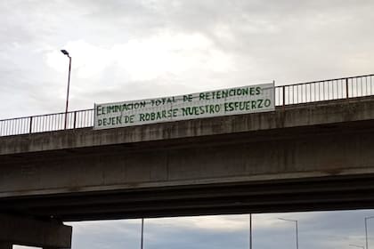 Un pasacalle con un pedido de autoconvocados sobre los derechos de exportación en la autopista Rosario-Córdoba, altura Marcos Juárez: "Eliminación total de retenciones. Dejen de robarse nuestro esfuerzo"