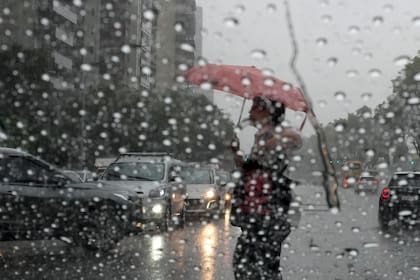 Un peatón cruza la calle mientras llueve en Buenos Aires, Argentina, el miércoles 20 de marzo de 2024