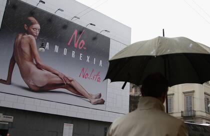 Un peatón pasa junto a un cartel publicitario de Nolita durante la semana de la moda Primavera/Veranoel 26 de septiembre de 2007 en Milán. Isabelle Caro, de 27 años, fue capturada desnuda por el controvertido fotógrafo Oliviero Toscani para la marca de ropa italiana Nolita de Flash & Partners. (Photo by Pascal Le Segretain/Getty Images)