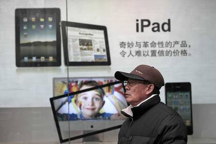 Un peatón pasa por el frente de la tienda de Apple en Shangai, China