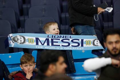 Un pequeño hincha inglés en el estadio Etihad, de Manchester City, con una bandera que reza "Lionel Messi, el mejor del mundo".