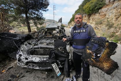 Un periodista exhibe equipo de seguridad quemado tras un ataque aéreo israelí contra un automóvil en la ciudad de Jezzine, al sur del Líbano, en el que murieron dos reporteros y un camarógrafo (AP/Mohammed Zaatari)