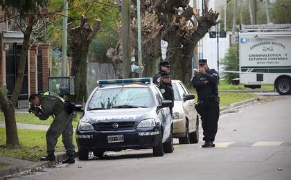 Un perito de la Gendarmería fotografía evidencias mientras policías de la Federal custodian la escena del hecho
