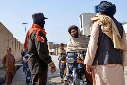 Un personal de seguridad afgano controla a un motociclista cerca del lugar de un ataque suicida con bomba en Kandahar el 21 de marzo de 2024.