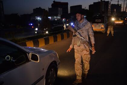 Un personal de seguridad detiene un vehículo en un punto de control en Herat, cuando se impuso un toque de queda nocturno