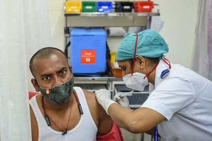 Un personal médico vacuna a un trabajador de la autoridad civil con una vacuna contra el coronavirus en el centro de vacunación del Hospital Nair en Mumbai el 16 de febrero de 2021