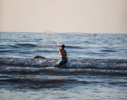 Un pescador artesanal lanza una red en el mar de Sayulita.