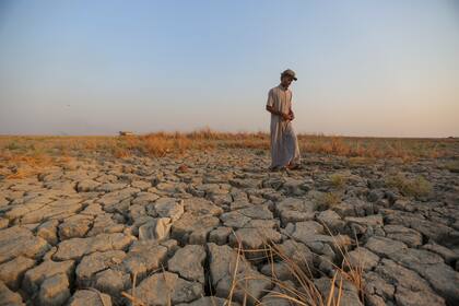 Un pescador camina por un terreno seco en las marismas de la provincia de Dhi Qar, Irak, 2 de septiembre de 2022. Tres años de sequía han afectado a millones de personas en Siria, Irak e Irán. (Foto AP/Anmar Khalil, Archivo)