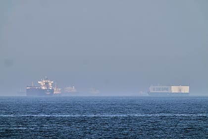 Un petrolero (izquierda) y un barco con autos, fondeados en el golfo de Omán, cerca del estrecho de Ormuz, vistos desde las costas de Khor Fakkan, Emiratos Árabes Unidos, el 1 de mayo de 2026. (AP Foto/Fatima Shbair)
