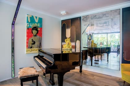 Un piano de cola, que suele tocar Mia, da paso al living. Detrás del piano, vemos, a la izquierda, una obra que Regina compró en una galería en Punta del Este. A la derecha, un collage de Julián Prebisch.
