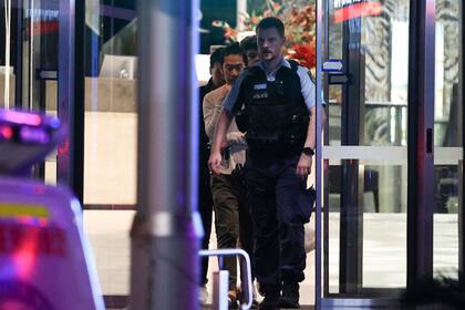 Un policía escolta a personas que estaban en el shopping después del incidente