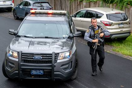 Un policía estatal de Pensilvania y otros oficiales buscan en Nantmeal Village a Danelo Cavalcante, quien se fugó de prisión a finales de agosto, el domingo 10 de septiembre de 2023. (Tom Gralish/The Philadelphia Inquirer vía AP)