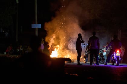 Un policía intenta apagar un incendio provocado en protesta contra los prolongados cortes de luz en La Habana, el 14 de mayo