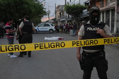 Un policía resguarda una escena del crimen en una calle de Durán, Ecuador, en julio de 2023, hasta ahora el año récord de violencia.