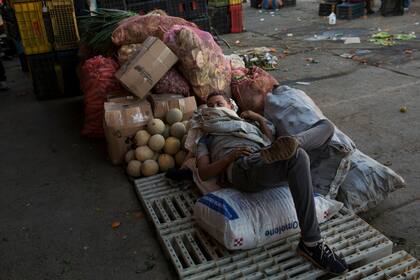 Un portero descansa en un mercado mayorista de alimentos en Caracas
