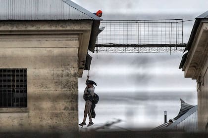 Un preso se cuelga de una soga mientras es sostenido por otro recluso