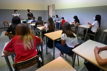 Un profesora con tapabocas se dirige a los alumnos, también con barbijos, el 14 de septiembre de 2020 al comienzo del año escolar en la escuela secundaria técnica Luigi Einaudi en Roma, durante la pandemia de coronavirus