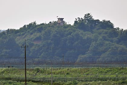 Un puesto de guardia norcoreano (arriba) en el lado norte de la Zona Desmilitarizada (DMZ) que divide las dos Coreas, se ve sobre una valla militar surcoreana (abajo) desde la ciudad fronteriza de Paju el 21 de junio de 2024.