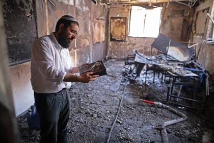 Un rabino inspecciona una escuela alcanzada por fuego palestino en Lod, cerca de Tel Aviv