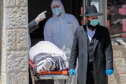 Un rabino israelí camina junto al cadáver, el exrabino sefardí de Israel Eliahu Bakshi-Doron, quien murió por complicaciones por coronavirus