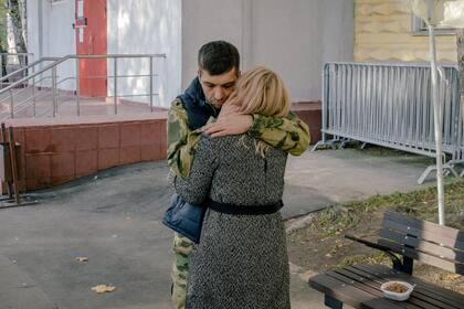 Un recluta ruso abraza a su pareja mientras se despide de ella en una oficina de reclutamiento en Moscú el martes 11 de octubre de 2022