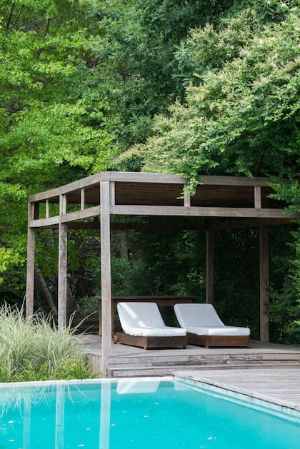 Un refugio al borde de la pileta. La vegetación mantiene fresco el techo de la pérgola. Un lugar aireado y sombrío para descansar. El desnivel del deck divide bien los dos sectores (Paisajista Sofía Zuberbuhler)