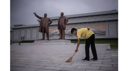 Un residente de Pyongyang realiza un trabajo voluntario frente a las estatuas de los ex líderes Kim Il-Sung y Kim Jong-Il, en la colina de Mansu