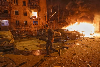 Un residente huye de un incendio tras el ataque con drones de Rusia en Járkiv, Ucrania, la noche del jueves 3 de abril de 2025. (AP Foto/Yevhen Titov)