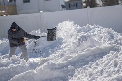 Un residente palea nieve después de que una tormenta de nieve azotara el noreste el 30 de enero de 2022 en Centereach, Nueva York. 