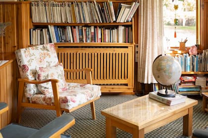 Un rincón de la hostería, con biblioteca y sillones tapizados con flores