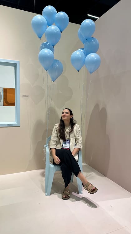 Un rincón lúdico de la feria, donde los globos celestes transforman la escena en un momento liviano y fantasioso.