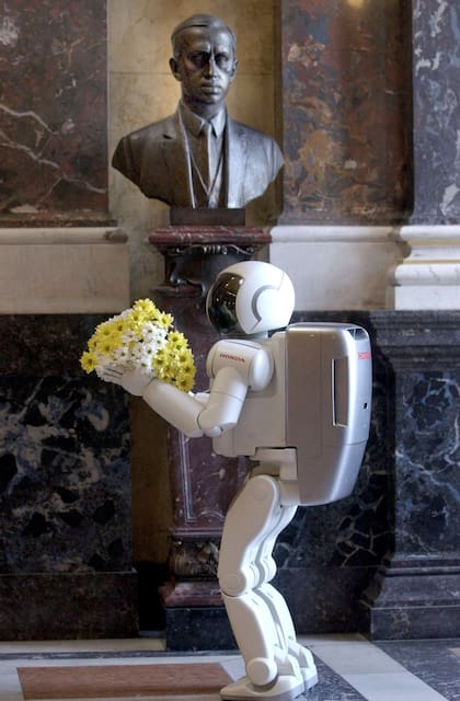 Un robot ofrece flores al busto de Karel Kapek en el Museo Nacional de Praga, en 2003