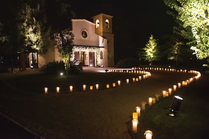 Un romántico camino alumbrado con velas conducía a la capilla, decorada con flores blancas por la ambientadora Marisa Tenguerian.