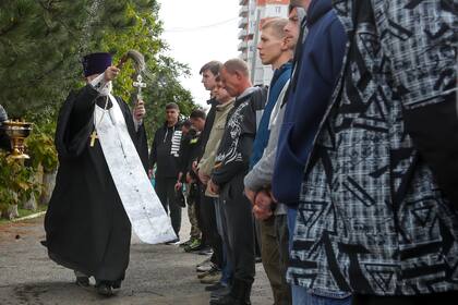 Un sacerdote ortodoxo ruso bendice a un grupo de reclutas en un centro de reclutamiento militar en Volgogrado, Rusia, el sábado 24 de septiembre de 2022. 