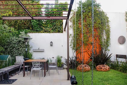 Un sector de 1,30 m de ancho se pintó de anaranjado y se cubrió con una malla por donde crece la Pyrostegia venusta (bignonia de invierno). Esta intervención hace de fuelle entre la pileta y la pérgola. El color se repite en la zona embutida que contiene la bacha debajo de la pérgola. Los bancos bajos móviles están realizados con planchuelas entrelazadas