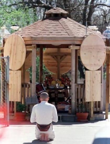 Un seguidor de Chen rezando en la casa del líder en Garland (Getty Images)