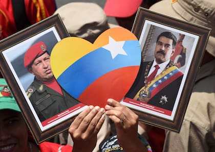 Un seguidor del chavismo, con los retratos de Hugo Chávez y Nicolás Maduro