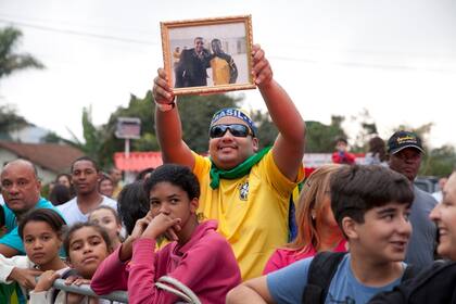 Un simpatizante brasileño muestra una foto con su ídolo "O Rey Pelé"
