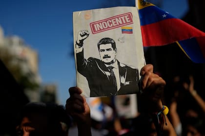 Un simpatizante del gobierno sostiene una pancarta con la imagen del expresidente Nicolás Maduro durante una marcha para exigir la liberación del mandatario y su esposa, Cilia Flores, un mes después de su captura por parte de las fuerzas armadas de Estados Unidos, el martes 3 de febrero de 2026, en Caracas