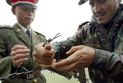 Un soldado chino y otro indio arreglan la alambrada en una zona de la frontera