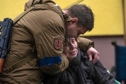Un soldado consuela a Larysa Kolesnyk, de 82 años, después de que fuera evacuada de Irpín, a las afueras de Kiev