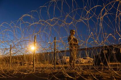 Un soldado de la Guardia Nacional de Texas hace vigilia en un campamento de migrantes improvisado cerca de la valla fronteriza entre Estados Unidos y México el 11 de mayo de 2023 en El Paso, Texas