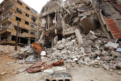 Un soldado de las fuerzas gubernamentales sirias camina entre los escombros en Zamalka, al este de Ghouta, el 11 de abril