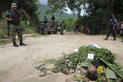Un soldado del Ejercito mexicano observa el cuerpo de uno de los cuatro agentes de la Policía Preventiva Rural que fueron asesinados en Acapulco,