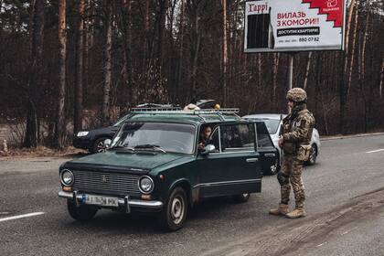 Un soldado del ejército ucraniano comprueba la documentación de un civil que huye de Irpin (Archivo)