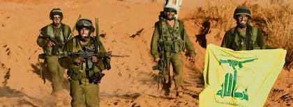 Un soldado israelí muestra como trofeo de guerra una bandera de Hezbollah, durante su regreso a Israel desde el sur del Líbano