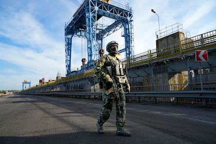 Un soldado ruso patrulla una zona de la central hidroeléctrica de Kakhovka, una central eléctrica de pasada en el río Dniéper, en la región de Kherson, al sur de Ucrania, el 20 de mayo de 2022. 