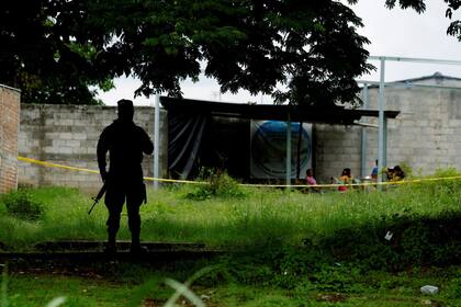 Un soldado salvadoreño asegura el perímetro del sitio donde las autoridades estaban excavando una fosa común clandestina descubierta en la casa de un ex policía que contenía muchos cuerpos, la mayoría de los cuales se cree que eran mujeres en Chalchuapa, El Salvador.