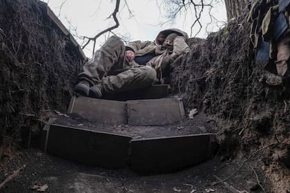 Un soldado ucraniano descansa en una trinchera en el frente de una guerra que no tiene fin a la vista 