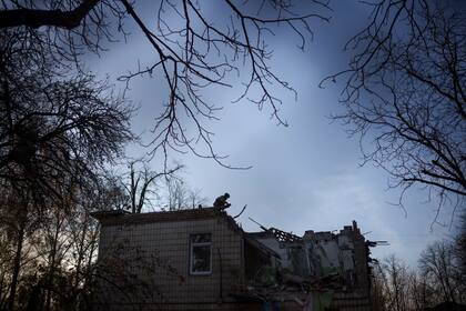 Un soldado ucraniano, en el tejado de un jardín de infantes que sufrió daños tras un ataque ruso con drones, en Kiev, Ucrania, el 25 de noviembre de 2023. (AP Foto/Felipe Dana)